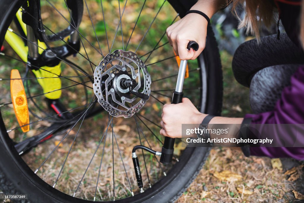 Frau reparaturt Fahrrad in der Natur.