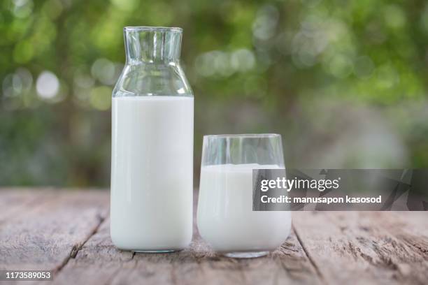 milk bottle and milk glass on wooden table - milk jug stock pictures, royalty-free photos & images