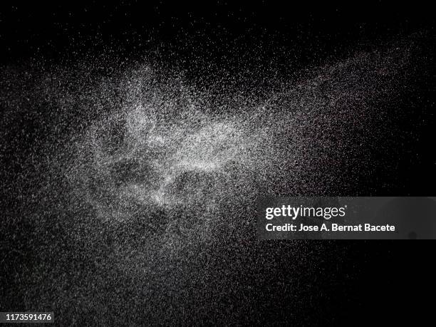 full frame of the textures formed by the water jets to pressure with drops floating in the air of color white on a black background - water spraying stock pictures, royalty-free photos & images