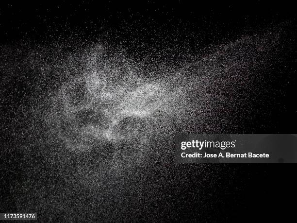 full frame of the textures formed  by the water jets to pressure with drops floating in the air of color white on a black background - water sprayer stock pictures, royalty-free photos & images