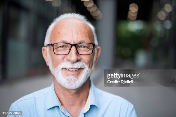 porträt eines glücklichen senior geschäftsmann. - männer über 40 stock-fotos und bilder