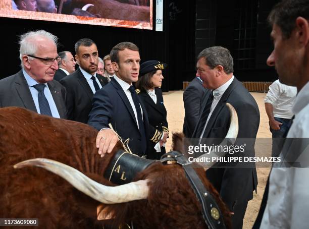 French president Emmanuel Macron talks with farmers on October 4 2019, during a visit to the "Sommet de l'Elevage" in Cournon d'Auvergne near...