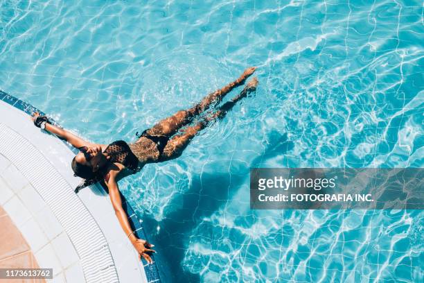 joven mujer negra en la piscina del complejo - beach hut fotografías e imágenes de stock