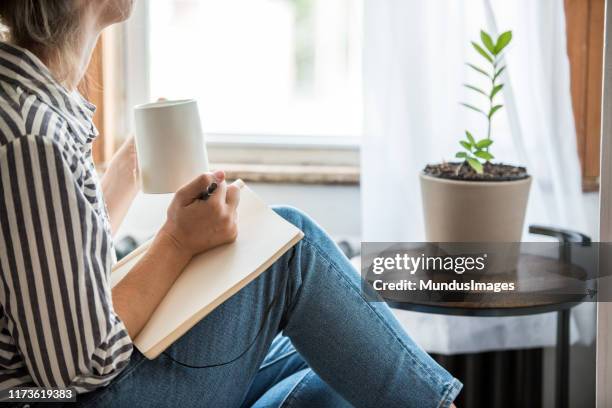 een jonge vrouw die een pauze neemt van technologie - journal stockfoto's en -beelden