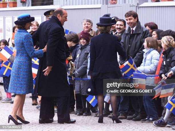 Le président Jacques Chirac est retenu par la reine Silvia de Suède, après l'avoir légèrement bousculée, lors d'un petit bain de foule au Palais...