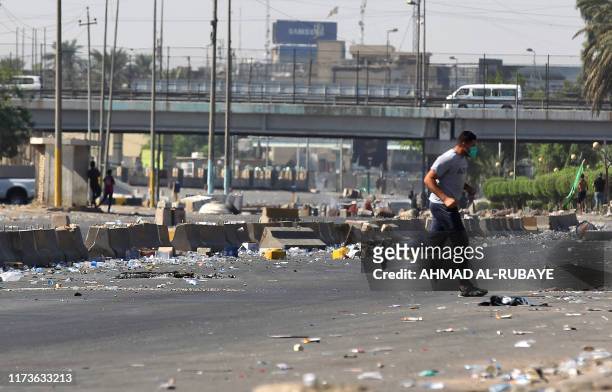 An Iraqi man runs as protesters try to demonstrate for the forth day against state corruption, failing public services, and unemployment in the Iraqi...