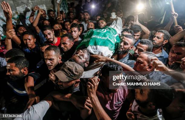 Graphic content / Palestinian mourners carry the body of 28-year-old Alaa Hamdan, who was killed earlier by Israeli fire during clashes along the...