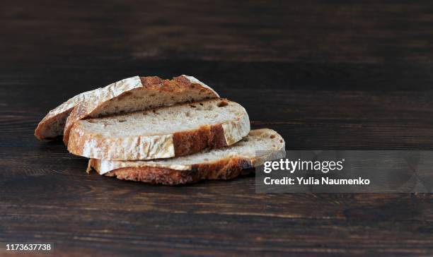 sliced black bread, homemade rye bread on a old dark wooden background. copy space. healthy eating. - dark bread stock pictures, royalty-free photos & images