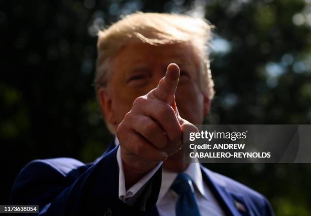President Donald Trump gestures at reporters as he departs the White House for Walter Reed hospital on the South Lawn on October 4, 2019.