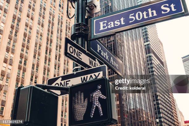 east 50th street and park avenue sign in midtown manhattan - walk signal stock pictures, royalty-free photos & images