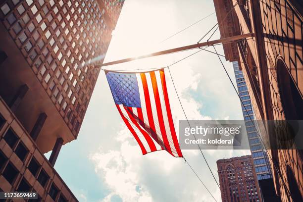 american flag in midtown manhattan - usa stockfoto's en -beelden