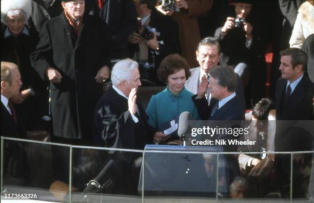 President Jimmy Carter takes the oath of office from Chief Justice of the Supreme Court Warren Burger on stage in front of the White House in January...