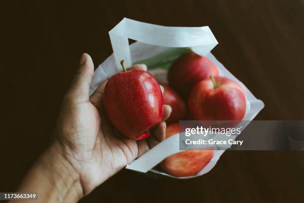 cropped view of hand holding apple - gala apples stock pictures, royalty-free photos & images