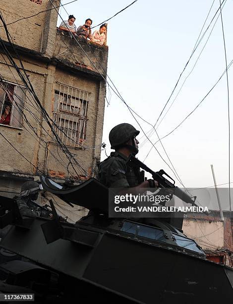 Marine on an armored personnel carrier patrols Rio de Janeiro's Morro da Mangueira shantytown early in the morning of June 19, 2011 in a...