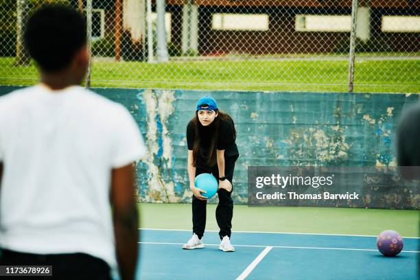 woman waiting for the opportunity to throw at opponent during dodgeball game - dodgeball photos et images de collection