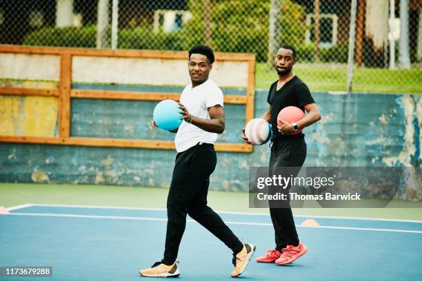 teammates preparing to throw balls during dodgeball game - dodgeball photos et images de collection