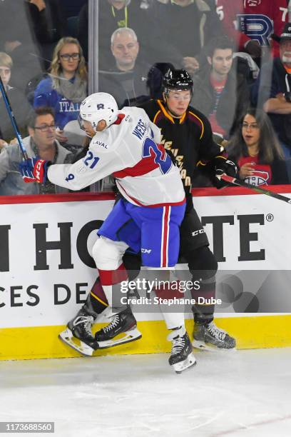 Dale Weise of the Laval Rocket checks Andrew Peeke of the Cleveland Monsters on the boards at Place Bell on October 4, 2019 in Laval, Quebec.