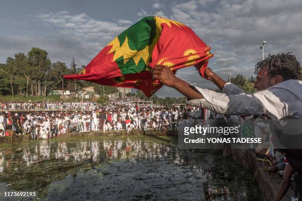 Man waves an Oromo flag as people from community of Oromo from different parts of Ethiopia gather at Meskel square in Addis Ababa, on October 5, 2019...