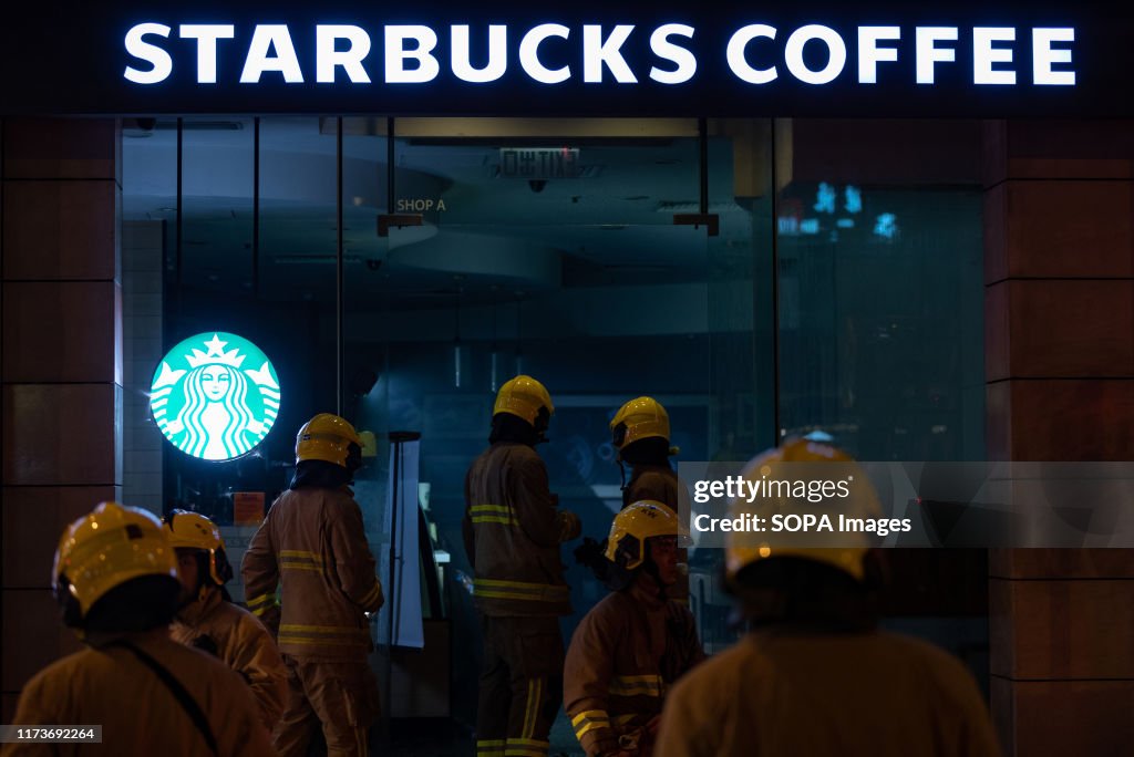 Firemen walk inside a Starbucks Coffee shop that was damaged...