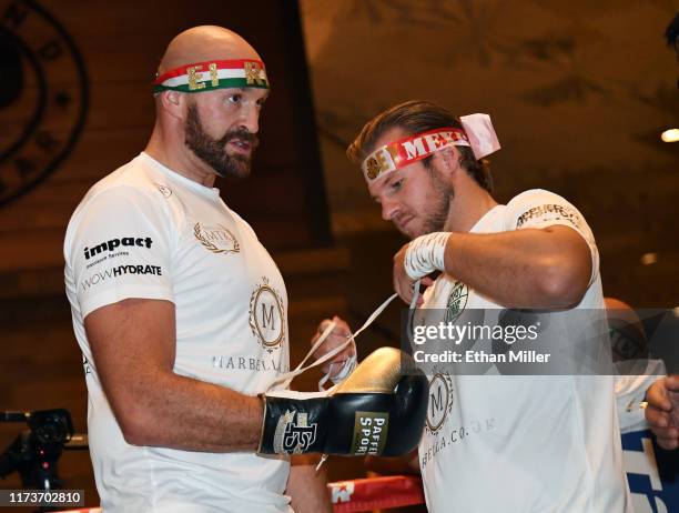 Trainer Ben Davison ties boxing gloves on boxer Tyson Fury;s hands during a workout at MGM Grand Hotel & Casino on September 10, 2019 in Las Vegas,...