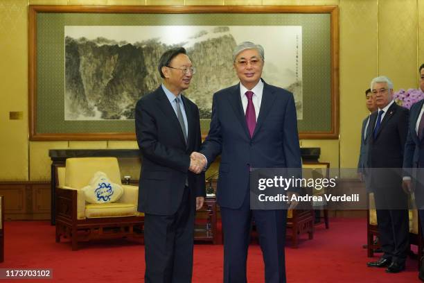 Member of the Politburo of the Communist party of China Yang Jiechi shakes hands with Kazak President Kassym Jomart Tokayev during the meeting on...