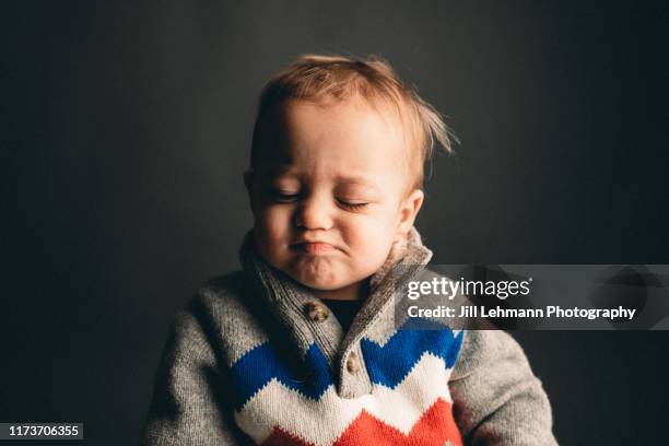 2 year old male toddler wearing sherpa ski sweater has tantrum and cries - mouth smirk stock pictures, royalty-free photos & images