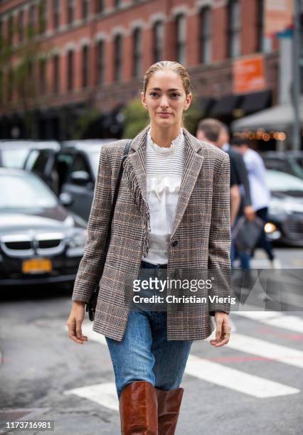 Sofia Sanchez de Betak is seen wearing denim jeans, checkered blazer, brown boots, white blouse outside Gabriela Hearst during New York Fashion Week...