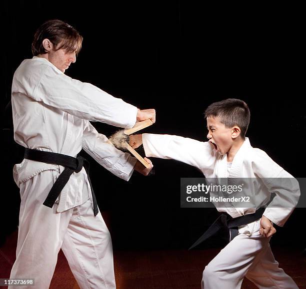 boy in karate outfit punching and breaking wood - kid punching stock pictures, royalty-free photos & images