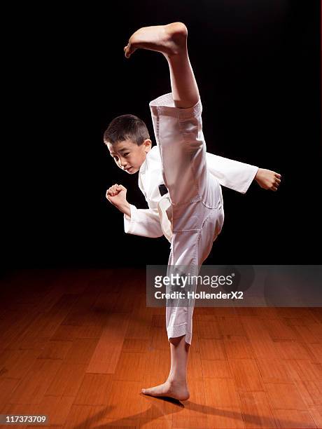 young boy with black belt in karate stance kicking - high kick stock pictures, royalty-free photos & images