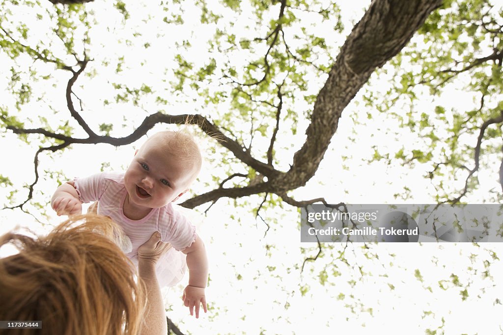 Mother playing with baby in park