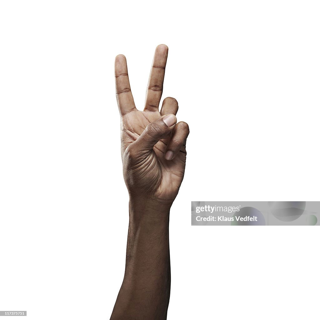 Close-up of male hand doing "peace" sign