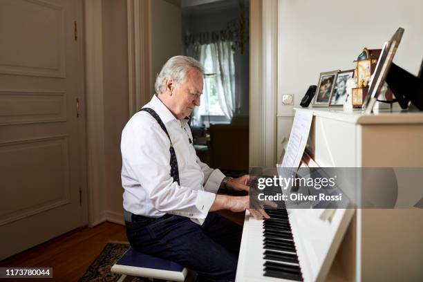 senior man playing piano at home - pianist stock pictures, royalty-free photos & images