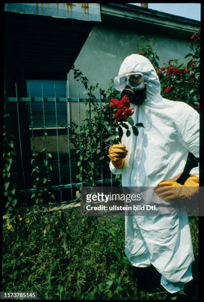 Man in protective suit with rose, Seveso 1981