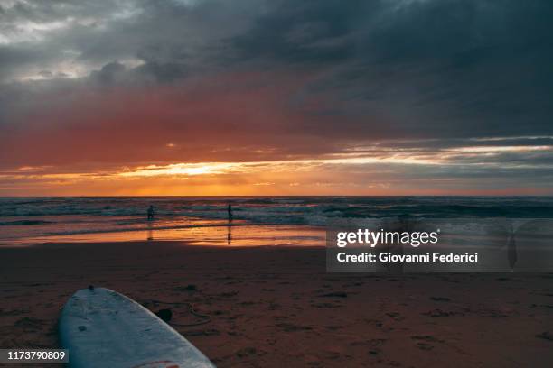 surfers at sunset on the beach - hossegor stockfoto's en -beelden