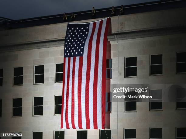 An American flag is unfurled on the side of the Pentagon to commemorate the anniversary of the 9/11 terror attacks September 11, 2019 in Arlington,...