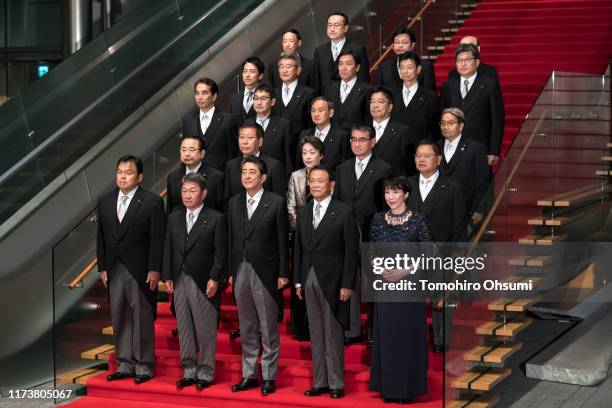 Japan's Prime Minister Shinzo Abe poses for a group photograph with his Cabinet members at the prime minister's official residence on September 11,...