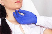 Doctor cosmetologist checks the skin for elasticity on a double chin in a girl, close-up, cosmetology, resilience