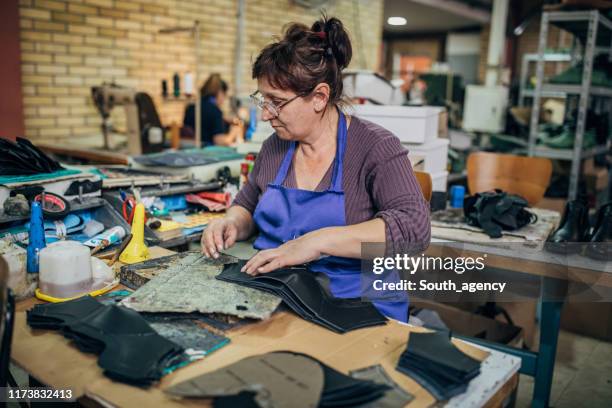 mature woman working hard at shoe factory - shoe factory stock pictures, royalty-free photos & images