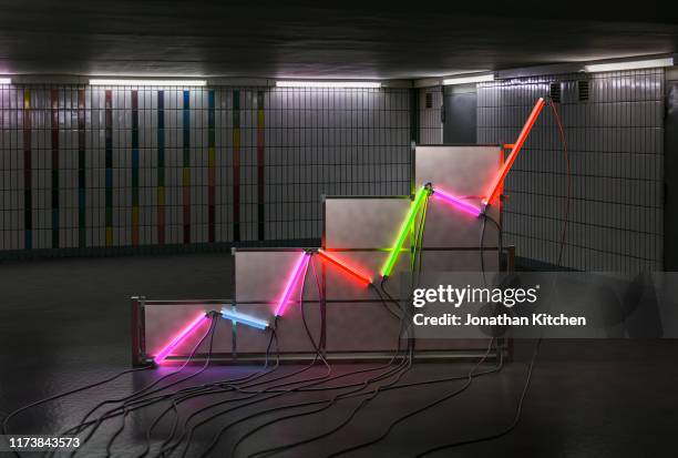 a graph made of neon tubes in a room - business graph stockfoto's en -beelden