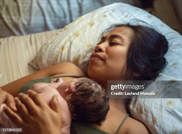 woman with just born infant on her chest - home birth 個照片及圖片檔