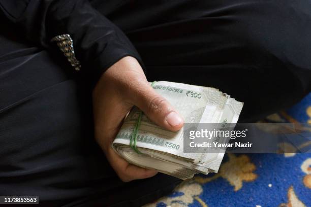 Kashmiri Muslim bride from the down-trodden section of the society holds the Mehar, dowry received from the Kashmiri Muslim groom during the Mass...