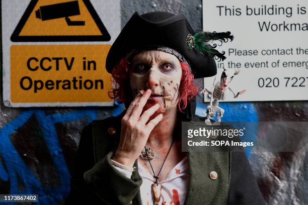Participant seen dressed as zombie pirate during the annual charity walk. People wearing zombie costumes gather in London to join efforts in an...