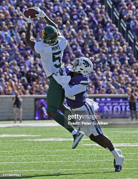 Wide receiver Denzel Mims of the Baylor Bears catches a pass against defensive back AJ Parker of the Kansas State Wildcats during the first half at...