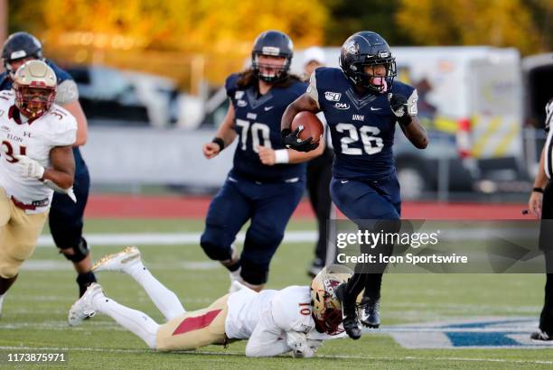 Wildcats running back Carlos Washington Jr. Skips away from Elon Phoenix defensive back Tre'Von Jones during a game between the UNH Wildcats and the...