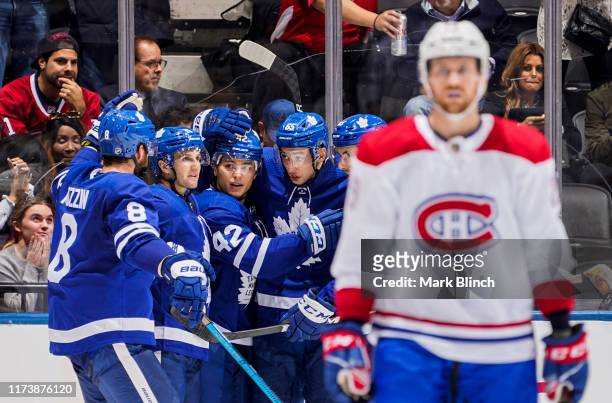 Trevor Moore of the Toronto Maple Leafs celebrates his goal against the Montreal Canadiens with teammates Jake Muzzin, Alexander Kerfoot and Ilya...
