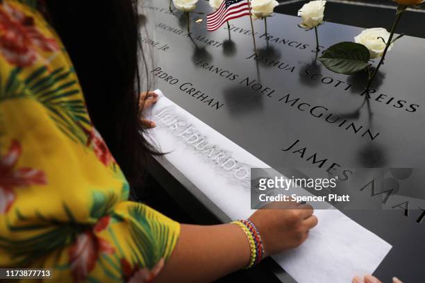 The niece of Luis Eduardo Torres, who was killed while working as a broker at Cantor Fitzgerald, copies out his name at the National September 11...