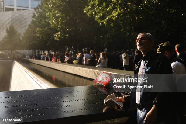 Friends and family of victims of the September 11 terrorist attacks, pause at the National September 11 Memorial during a morning commemoration...
