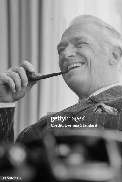 American actor and producer Douglas Fairbanks Jr smoking a pipe, UK, 24th July 1970.