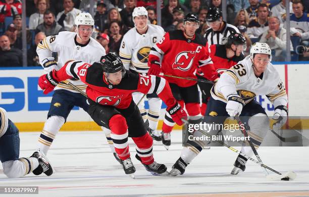 Jeff Skinner of the Buffalo Sabres controls the puck against Damon Severson of the New Jersey Devils during an NHL game on October 5, 2019 at KeyBank...