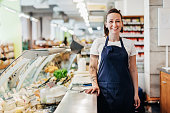 Portrait Of Supermarket Clerk Standing At Counter